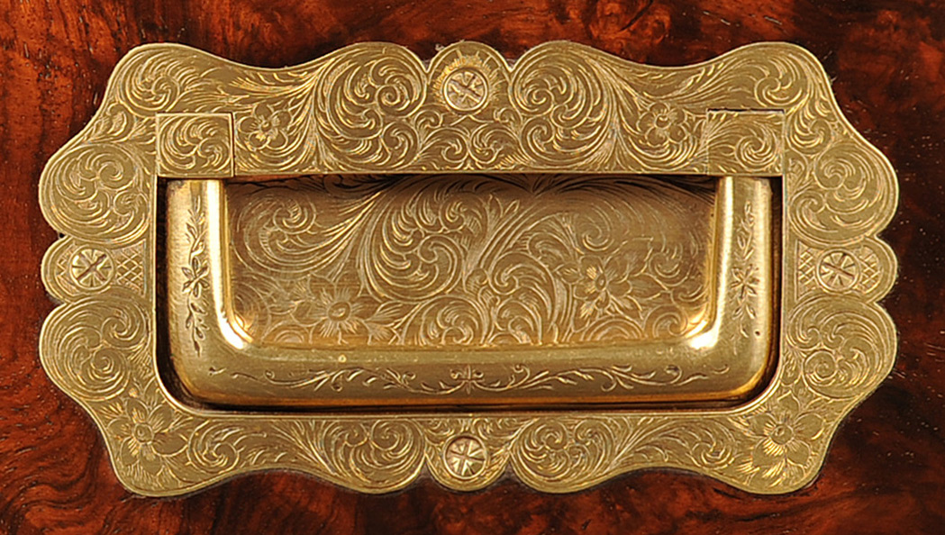 Sculpted and engraved brass handle from an antique jewellery box in figured walnut.