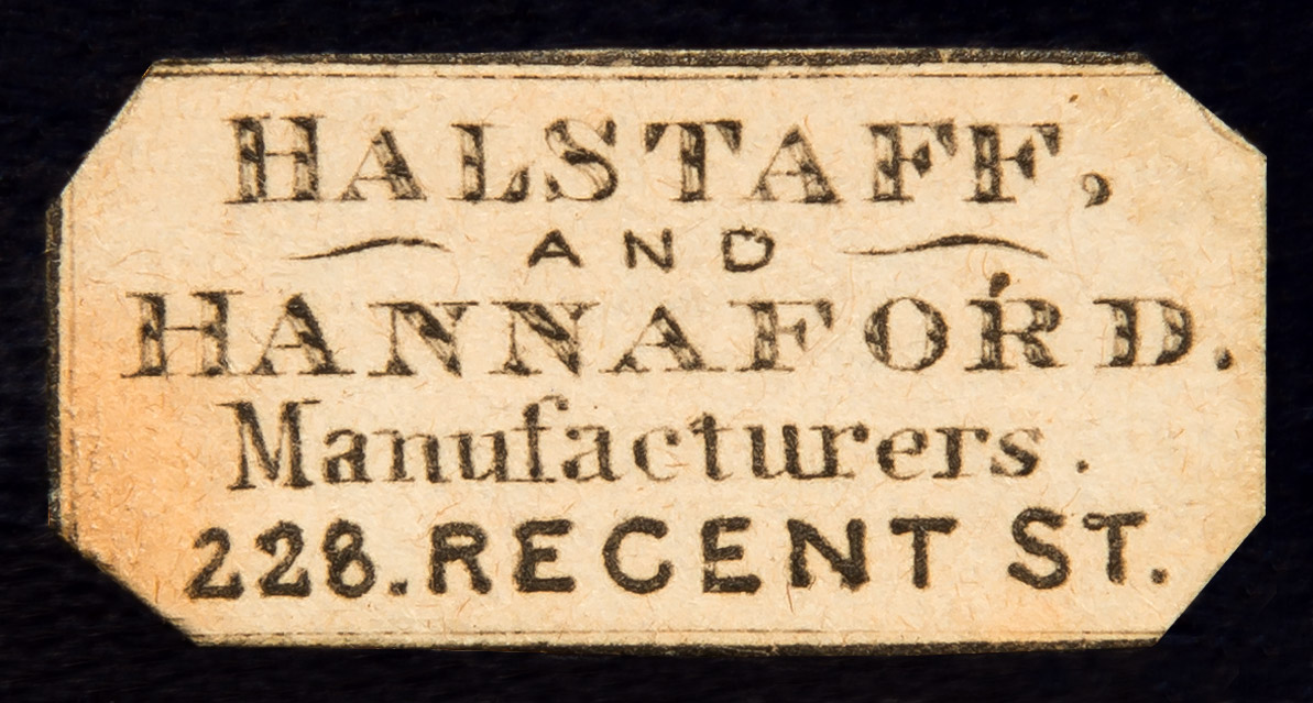 Removing the mirror/ ruched velvet panel in the lid reveals a concealed leather-bound letter wallet behind. Adhered to the interior of the letter wallet is this label belonging to the manufacturer and retailer, Halstaff & Hannaford of 228 Regent Street, London.
