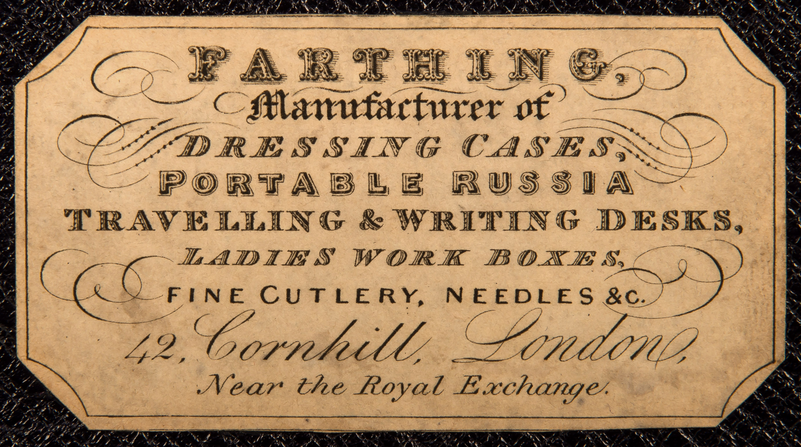 Removing the ruched velvet/ mirror panel in the lid reveals this paper maker’s label adhered to the concealed leather-bound letter wallet behind. This label bears the mark of the manufacturer and retailer, John Farthing of 42 Cornhill, London.